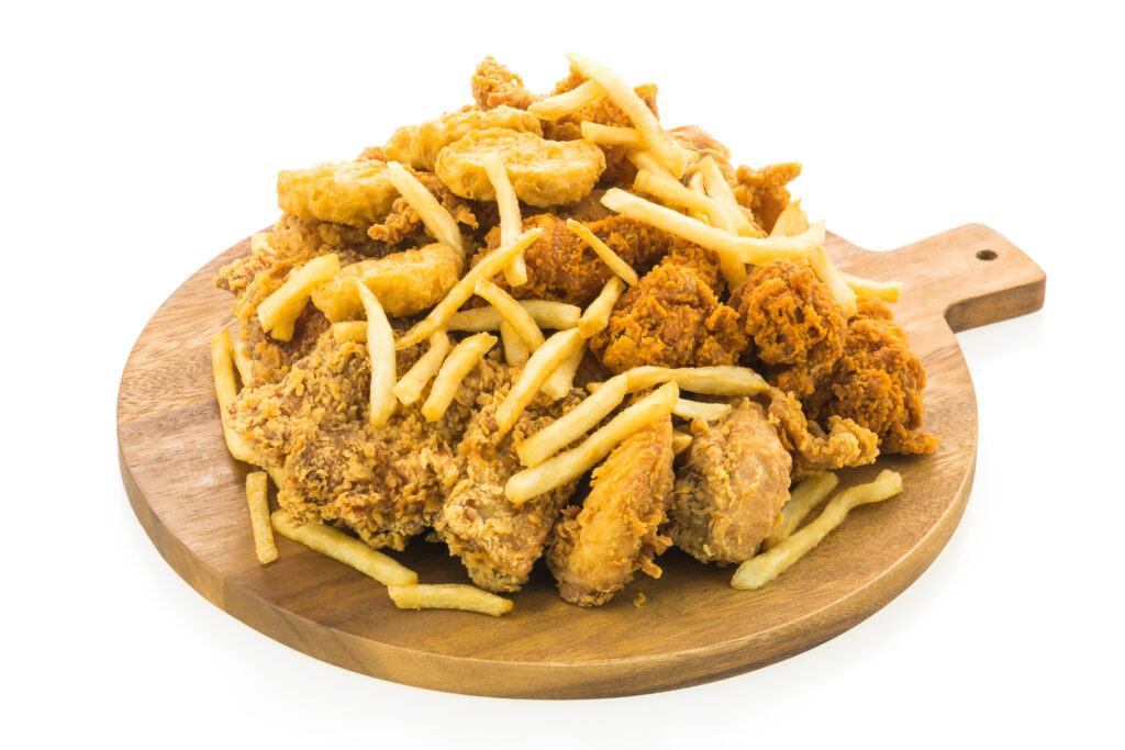 french fries and fried chicken on wooden plate
